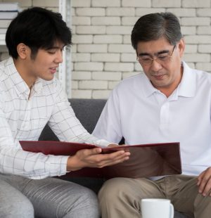 Young man agent recommending life insurance to senior man.
